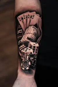 Black and grey casino sleeve tattoo with dice and poker chips by All City Tattoo