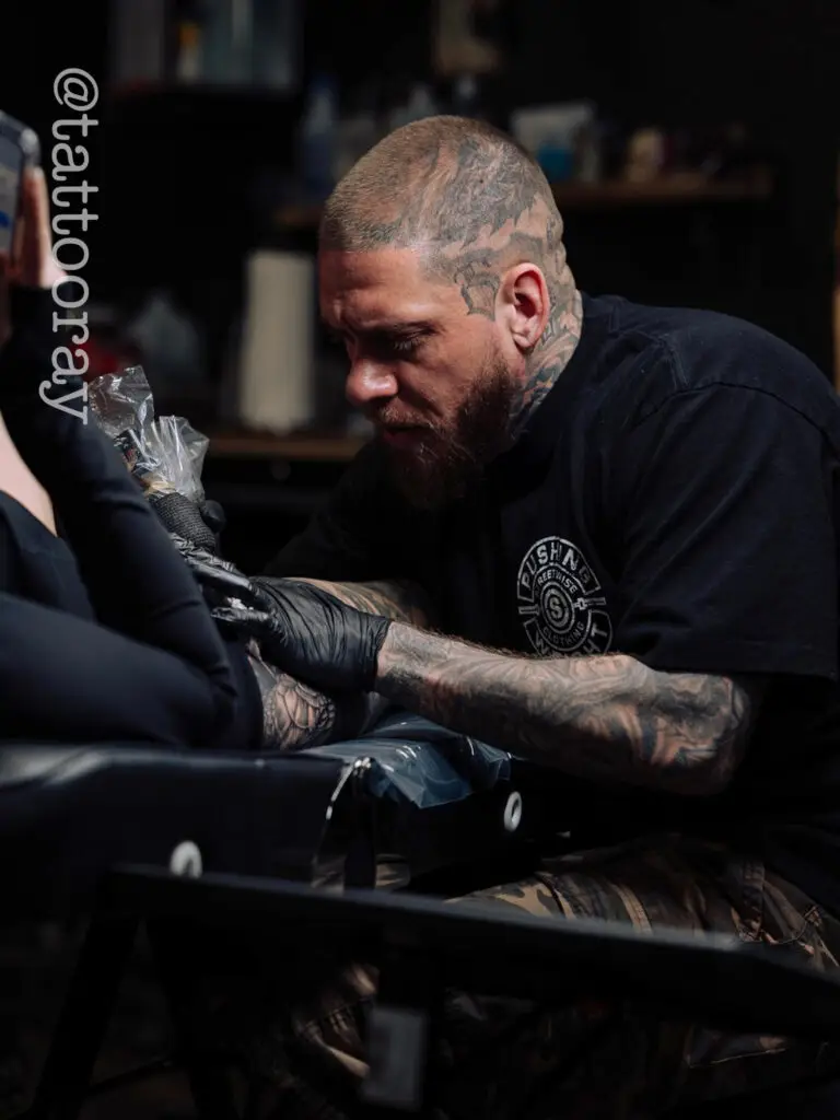 Tattoo artist Ray working with a client at All City Tattoo Company in Delray Beach